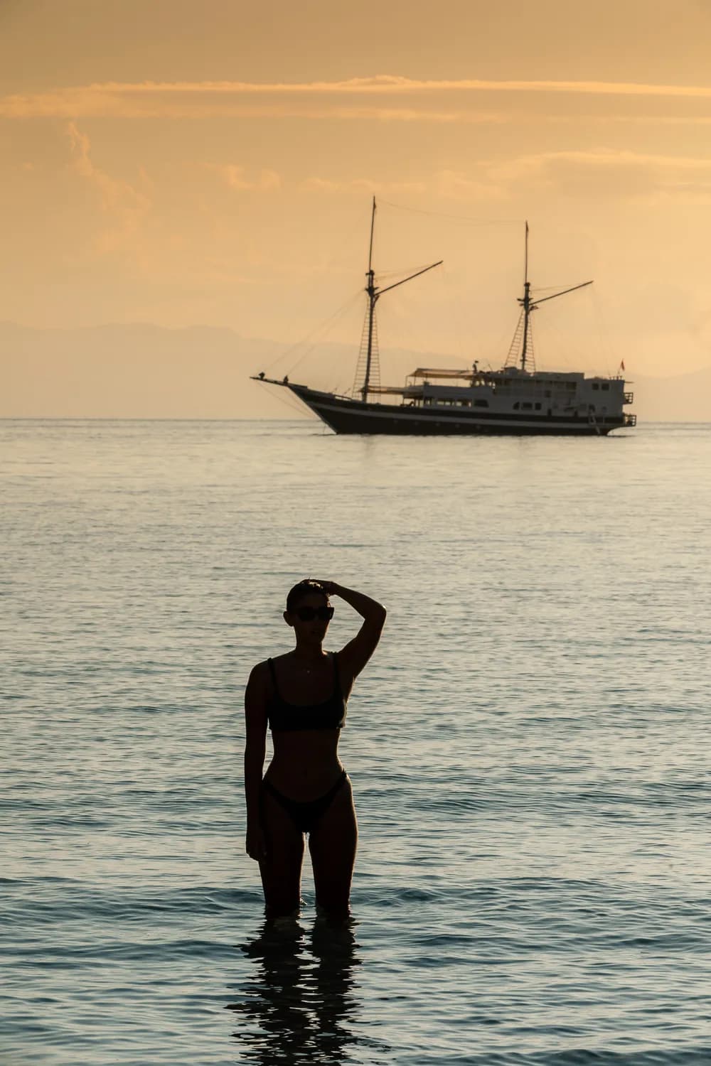 Woman silhouette sunset luxury liveaboard Indonesia