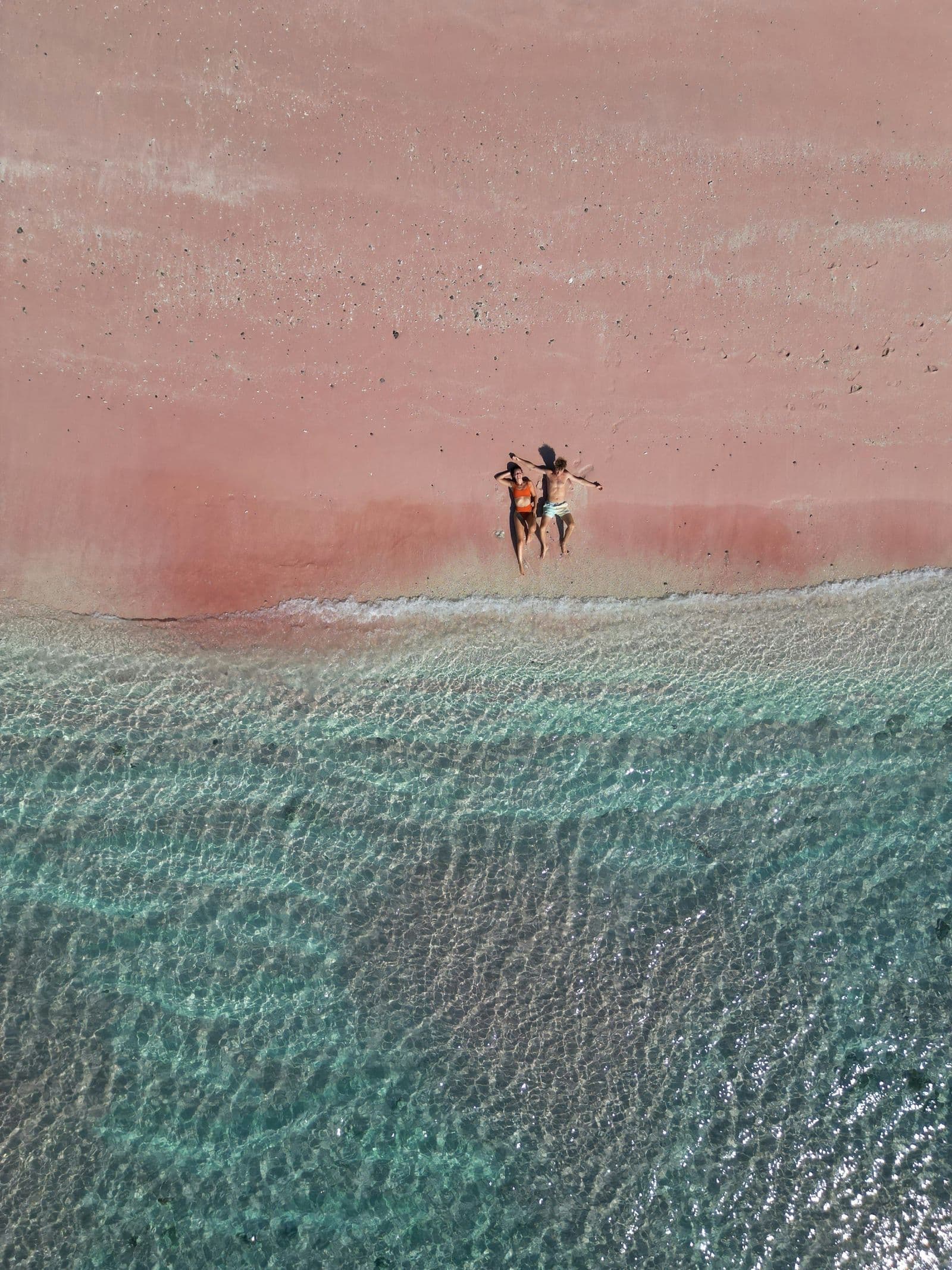 Pink beach aerial view couple Indonesia liveaboard destination romantic diving cruise